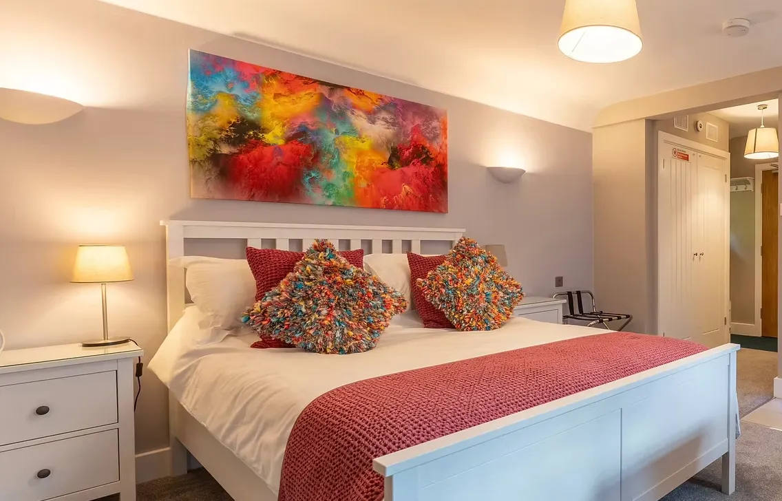 Room Two with a made bed and abstract artwork